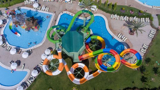 मनोरंजन थीम पार्क में ग्राउंड पूल स्लाइड किड्स के ऊपर बड़े खेल उपकरण लगे हैं